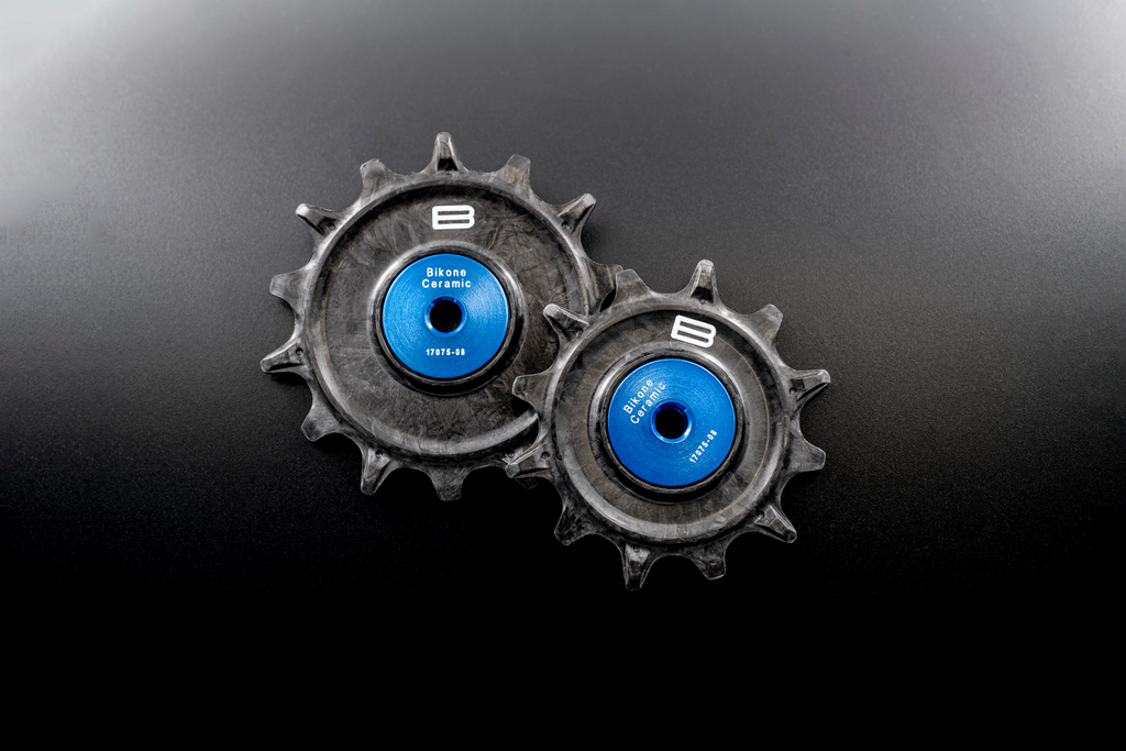 Bikone Forged Carbon Pulley Wheels, the pair side by side on a black background, road bike drivetrain components