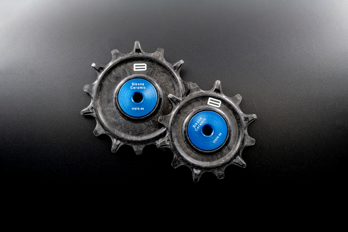 Bikone Forged Carbon Pulley Wheels, the pair side by side on a black background, road bike drivetrain components