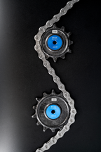 Bikone Forged Carbon Pulley Wheels, upper and lower pulleys with a chain routed between them, road bike drivetrain components